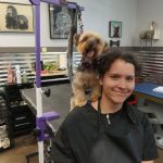 Apprentice smiling at a camera with a dog in the background